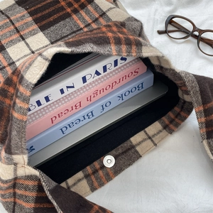 Detail of spacious plaid wool tote interior holding a laptop and books with magnetic closure