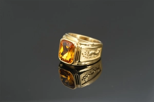 Detailed relief of Chinese dragon on gold ring featuring a large amber gemstone