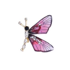 Macro shot of purple butterfly brooch with gold metal frame and sparkling crystal details