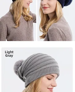 Détail du bonnet en tricot gris clair avec texture côtelée, boutons latéraux et pompon