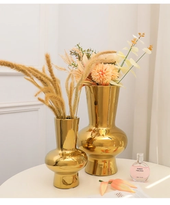 Detail of elegant gold electroplated ceramic vases with reflective mirror finish