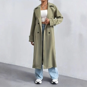Detail of olive green double-breasted trench coat with lapels and epaulettes on a model
