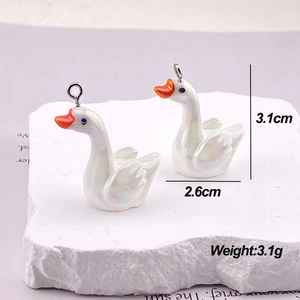 Detailed view of iridescent white swan charms with 3.1cm height and metal loops