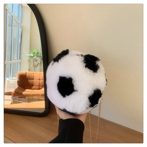 Detail of plush soccer-shaped crossbody bag with soft faux fur and gold chain strap