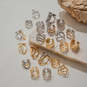 Detailed view of layered gold and silver stainless steel rings on stone pedestal
