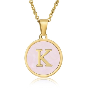 Macro shot of gold pendant featuring a pink shell inlay with a metallic letter K