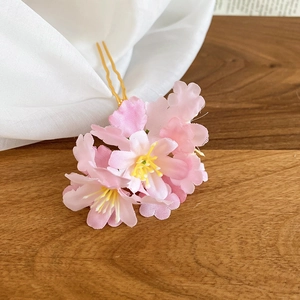 Detailed view of handmade pink fabric cherry blossom hair fork on a wooden table