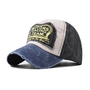 Detail of distressed vintage baseball cap with racing patch and worn brim texture