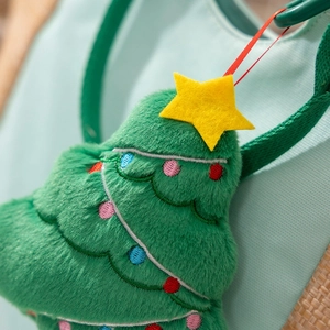 Close-up of a green plush Christmas tree charm with colorful embroidery and yellow star