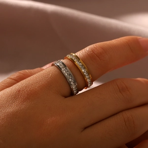 Detailed macro of gold and silver channel-set square zircon rings on silk fabric