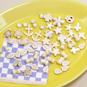 Detailed view of white turquoise beads in star, cross, and dolphin shapes for jewelry DIY