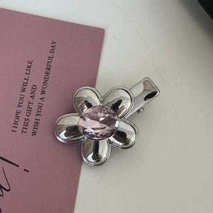 Elegant silver flower hair clip featuring a sparkling pink crystal center and polished finish
