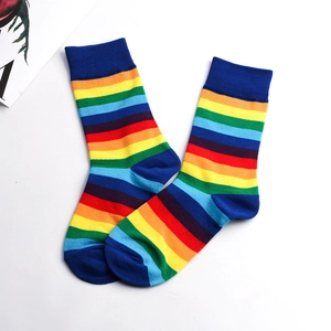 Detailed view of rainbow striped crew socks with dark blue ribbed cuffs and toes