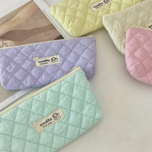 Close-up of quilted diamond pattern on macaron-colored multipurpose cosmetic bags