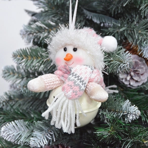 Close-up of plush snowman Christmas bell ornament with pink scarf on tree branch