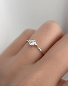 Macro shot of a classic six-prong moissanite silver ring on a model's finger