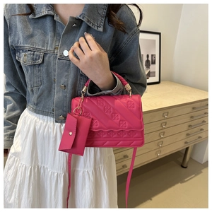 Detail of rose red embossed tote bag with floral stitching and matching small coin purse