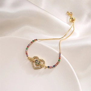 Detail of adjustable gold bracelet with micro-paved heart and multi-colored zircons