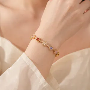 Vintage style gold bracelet with colorful square zircons worn on woman wrist