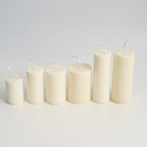 Detailed view of six ribbed beige pillar candles with elegant vertical striped texture