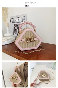 Detailed view of pink hexagon straw woven handbag with gold chain and pleated handle