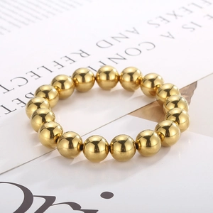 Macro view of mirror-polished golden ball bead bracelet with high metallic reflection