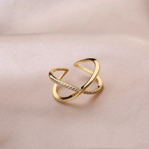 Detailed view of a gold-plated X-shaped ring with minimalist pave zircon inlay
