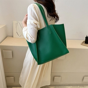 Minimalist green PU leather tote bag shown on shoulder in a bright home setting
