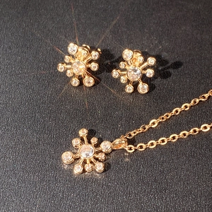Makroaufnahme von Goldschmuck-Set mit glitzernden Kristallen auf schwarzem Grund