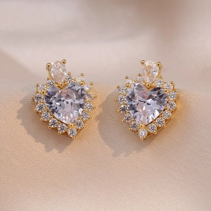 Macro detail of luxury heart-shaped zircon earrings with sparkling 18K gold-plated setting