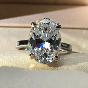 Macro shot of an oval-cut moissanite stone in a classic four-prong 925 silver setting
