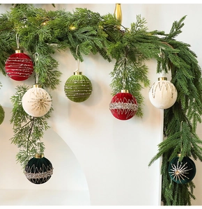 Detailed view of velvet Christmas balls with glitter and bead patterns on pine branch