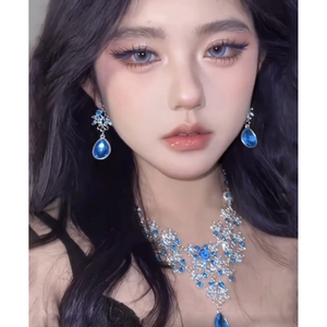 Detail of luxury zircon hollow flower necklace and blue teardrop earrings on model