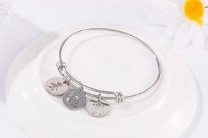 Detailed shot of silver stainless steel bracelet with cutout girl and LOVE charms