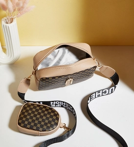Detail view of retro monogram camera bag with matching round coin purse and wide strap