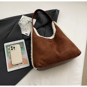 Detail of brown suede tote bag featuring plush white faux fur trim and leather straps