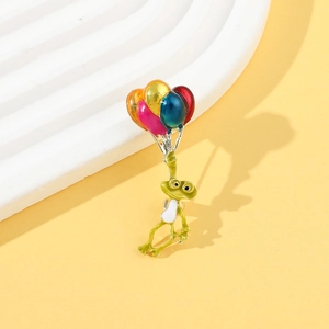 Détail de la broche grenouille à ballons colorés en émail avec finition métallique