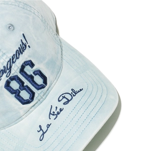 Detail of 3D embroidered 86 and Gorgeous script on washed light blue baseball cap