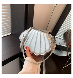 Detailansicht der silbernen Muscheltasche mit Perlengriff und strukturierter Oberfläche