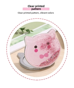 Detail of pink cat-shaped quicksand makeup mirror with sparkling glitter on wooden background