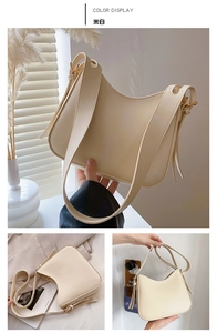 Detail of cream crescent bag featuring adjustable strap and sleek leather texture