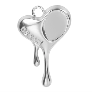 Macro shot of silver heart pendant with melting drop effect and DREAM engraving
