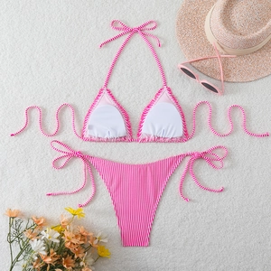 Detailed flat lay of pink striped halter bikini set with summer beach accessories