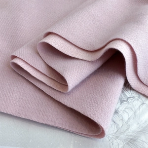 Macro shot of pink imitation cashmere scarf fabric showing soft diagonal twill texture