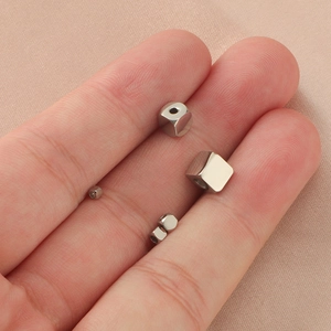 Mirror finish stainless steel cube beads in various sizes displayed on fingers