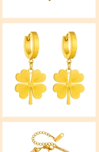 Close-up of golden four-leaf clover earrings and matching stainless steel necklace detail
