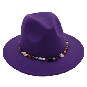 Detail of purple felt fedora hat featuring an ethnic style beaded band with wooden accents