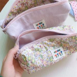 Detalle del estuche de pana lila y lona floral con etiqueta bordada de un tulipán
