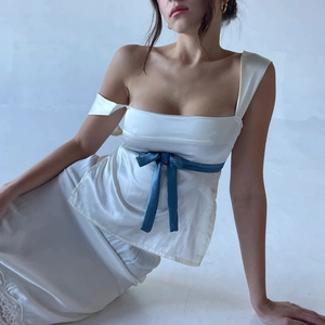Detailansicht des weißen Satin-Halterneck-Tops mit kontrastierenden blauen Bändern zum Schnüren
