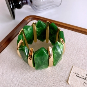 Detail of green marble resin and gold metal segments on the elastic stretch bracelet